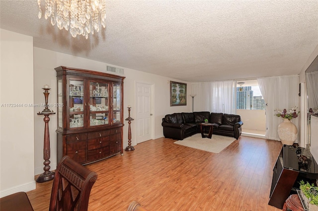 1833 S Ocean Dr Unit 1808, Hallandale Beach, FL 33009 - living area featuring light wood-style flooring, a textured ceiling, baseboards, and a chandelier