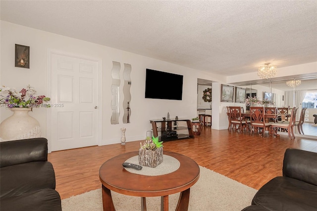 1833 S Ocean Dr Unit 1808, Hallandale Beach, FL 33009 - living room featuring a chandelier, wood finished floors, a textured ceiling, and baseboards
