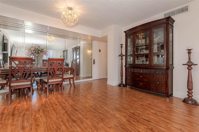 1833 S Ocean Dr Unit 1808, Hallandale Beach, FL 33009 - dining space featuring a chandelier, wood finished floors, a textured ceiling, and baseboards