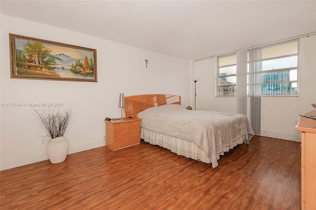 bedroom with dark wood-type flooring and a textured ceiling