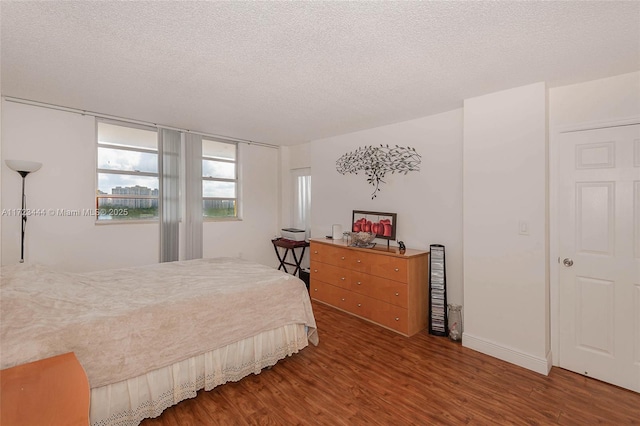 bedroom with hardwood / wood-style flooring and a textured ceiling