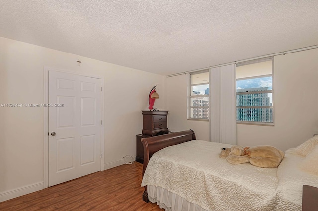 bedroom featuring hardwood / wood-style flooring and a textured ceiling