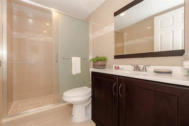 bathroom featuring tile patterned floors, vanity, toilet, and walk in shower