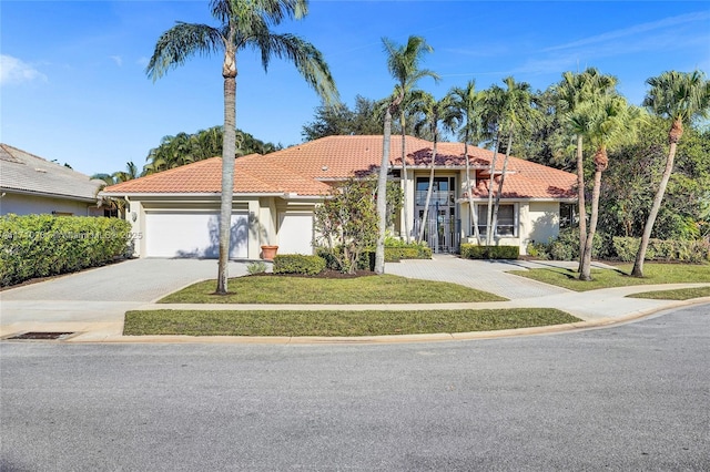 mediterranean / spanish-style house featuring a garage and a front lawn