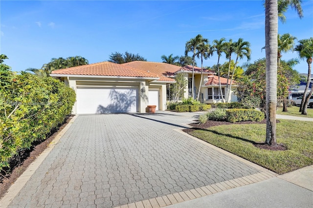 mediterranean / spanish home with a front lawn and a garage