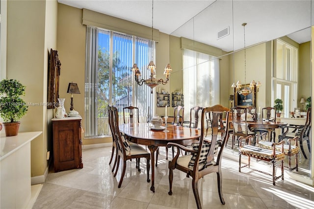 dining space featuring light tile patterned flooring and a chandelier