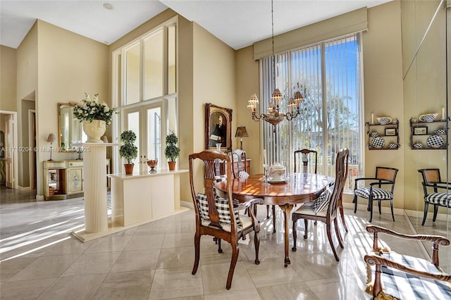 dining room featuring a towering ceiling, a notable chandelier, and light tile patterned flooring