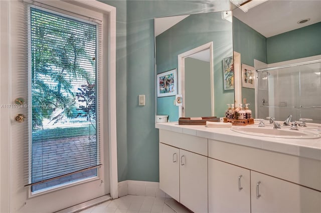 bathroom featuring tile patterned flooring, vanity, and walk in shower