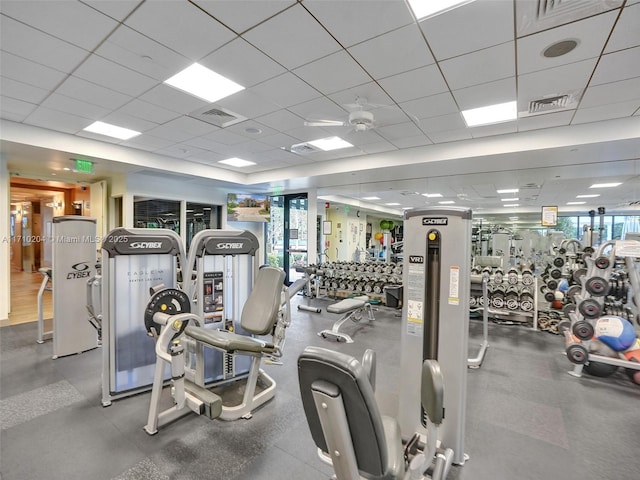 exercise room with ceiling fan and a drop ceiling