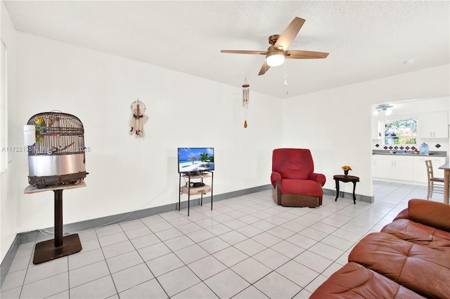 tiled living room featuring ceiling fan and a textured ceiling