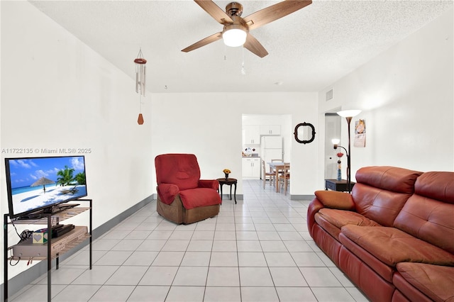 tiled living room featuring ceiling fan and a textured ceiling