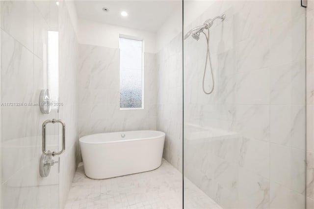 bathroom with tile walls and independent shower and bath