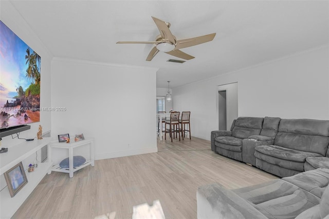 living room with light wood-type flooring, ceiling fan, and crown molding