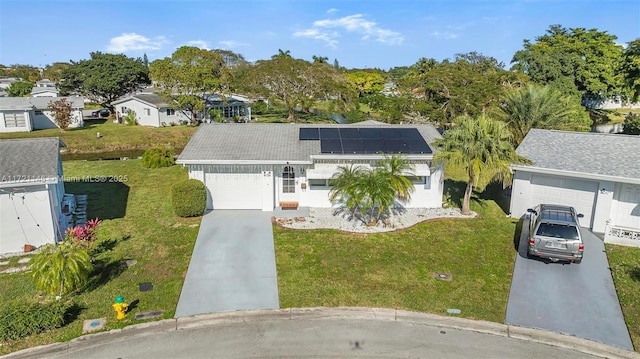 view of front of home with a front lawn, a garage, and solar panels