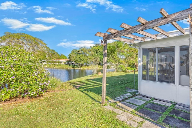 view of yard featuring a water view and a pergola