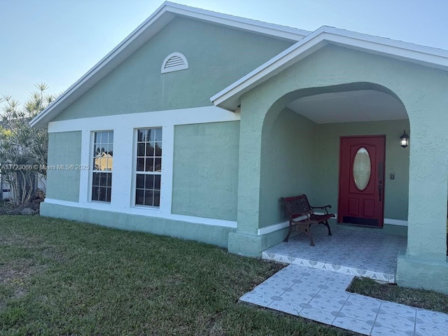 doorway to property featuring a yard