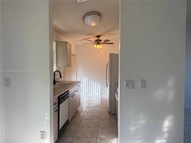 kitchen featuring a textured ceiling, ceiling fan, white appliances, and sink