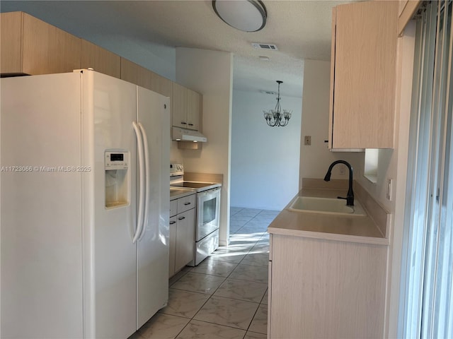 kitchen featuring light brown cabinetry, sink, and white appliances