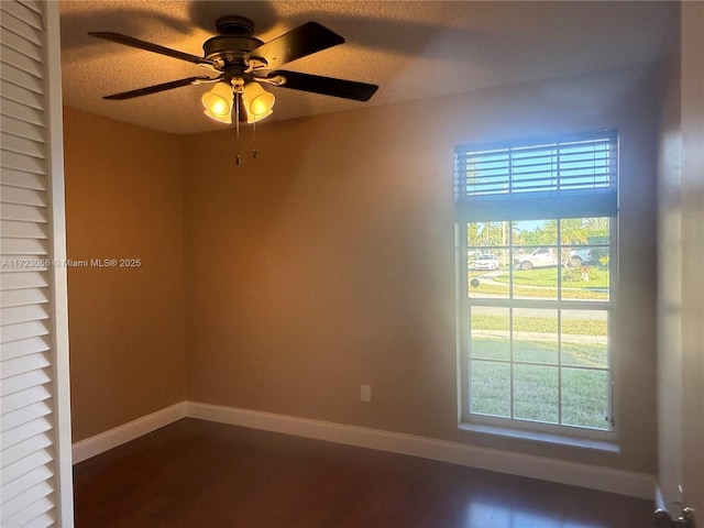 unfurnished room featuring a textured ceiling, dark hardwood / wood-style floors, and ceiling fan