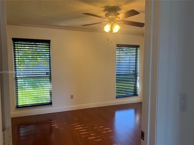 spare room featuring a textured ceiling, ceiling fan, dark hardwood / wood-style floors, and crown molding