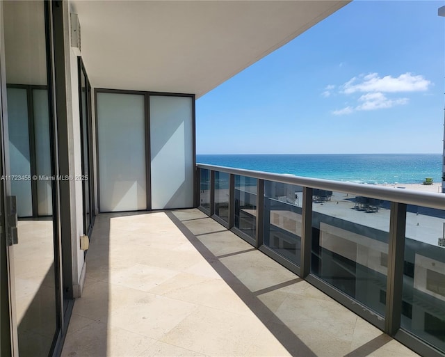 balcony with a water view and a beach view