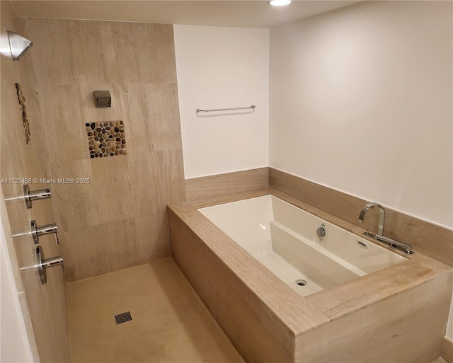 bathroom with a relaxing tiled tub