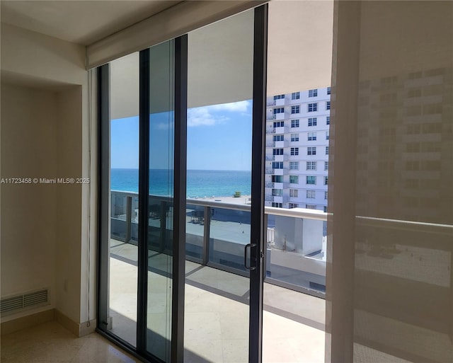 balcony with a water view and a view of the beach