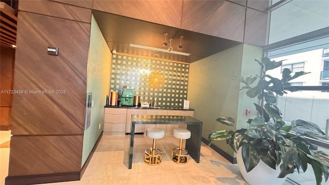 wine room featuring light tile patterned floors and indoor bar