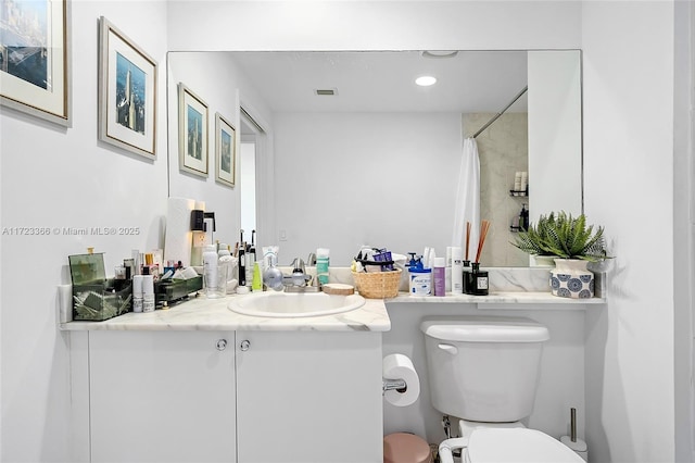 bathroom with a shower with shower curtain, vanity, and toilet