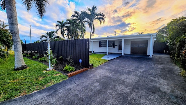 ranch-style home featuring a carport and a yard