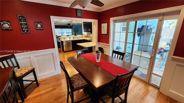 dining room with ceiling fan, light hardwood / wood-style floors, sink, and crown molding