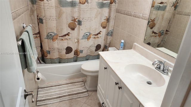 full bathroom with vanity, shower / bath combo, tile patterned floors, toilet, and tile walls