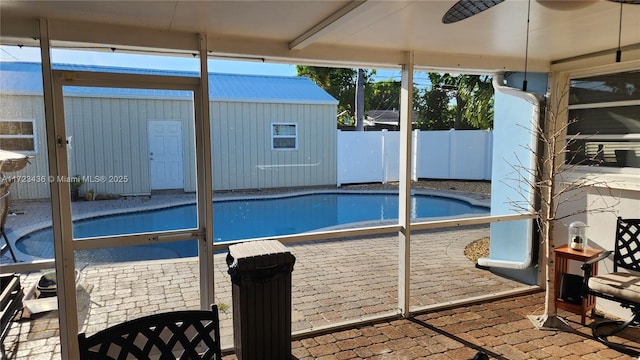 view of swimming pool with ceiling fan and a patio area