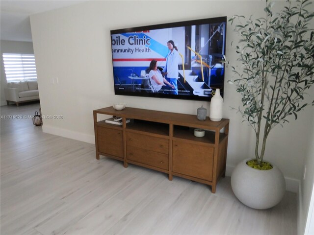 kitchen with a kitchen breakfast bar, stainless steel fridge, kitchen peninsula, and white cabinetry