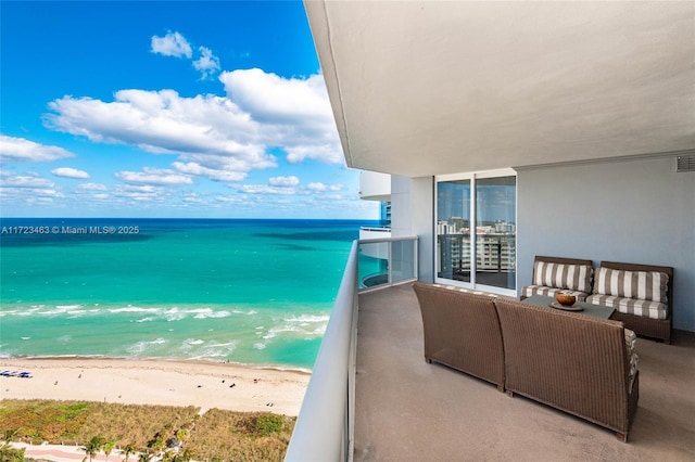 balcony with a water view and a view of the beach