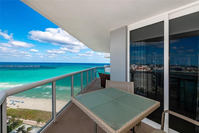 balcony featuring a beach view and a water view