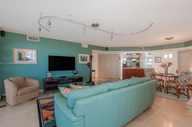 tiled living room with crown molding and rail lighting