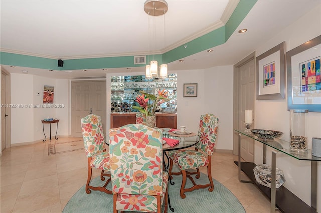 tiled dining area featuring an inviting chandelier and ornamental molding