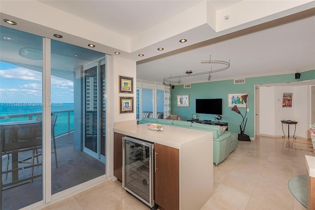 kitchen with light tile patterned floors, kitchen peninsula, and wine cooler