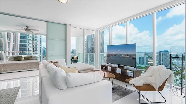 living room featuring ceiling fan, plenty of natural light, and a wall of windows