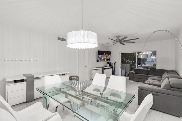 dining space with ceiling fan with notable chandelier