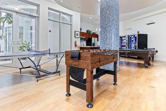 playroom featuring decorative columns, ceiling fan, light hardwood / wood-style flooring, billiards, and a high ceiling