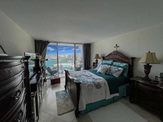 bedroom featuring light tile patterned floors, a wall of windows, and access to outside