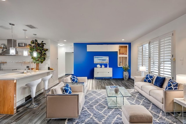 living room with hardwood / wood-style flooring and sink