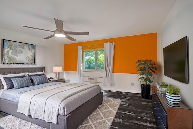 bedroom with dark hardwood / wood-style flooring and ceiling fan