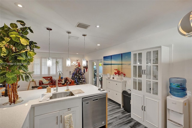 kitchen featuring dishwasher, sink, dark hardwood / wood-style flooring, pendant lighting, and white cabinets