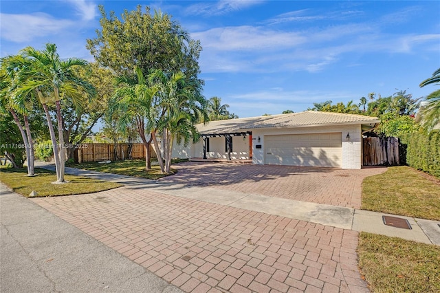 single story home with a garage and a front yard