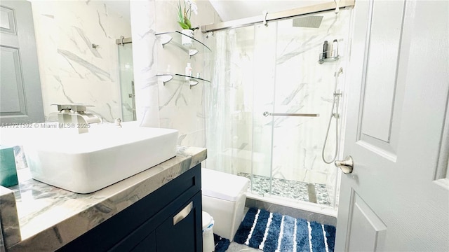 bathroom featuring toilet, tiled shower, and vanity