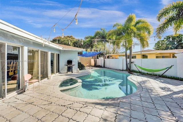view of swimming pool with a fenced backyard, a patio area, and a pool with connected hot tub