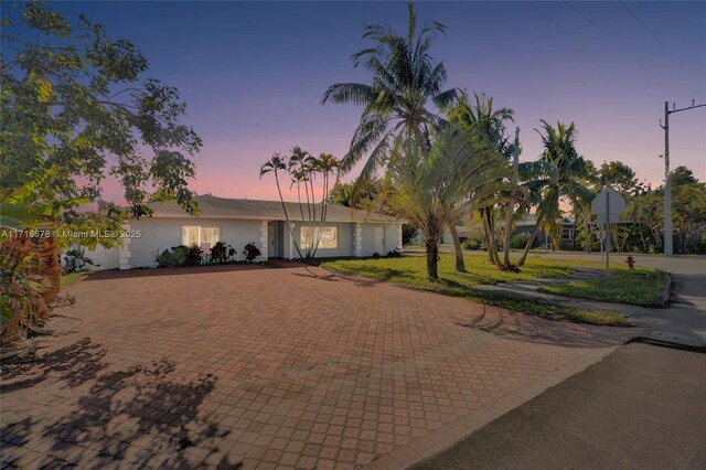 view of front of house with a lawn and stucco siding